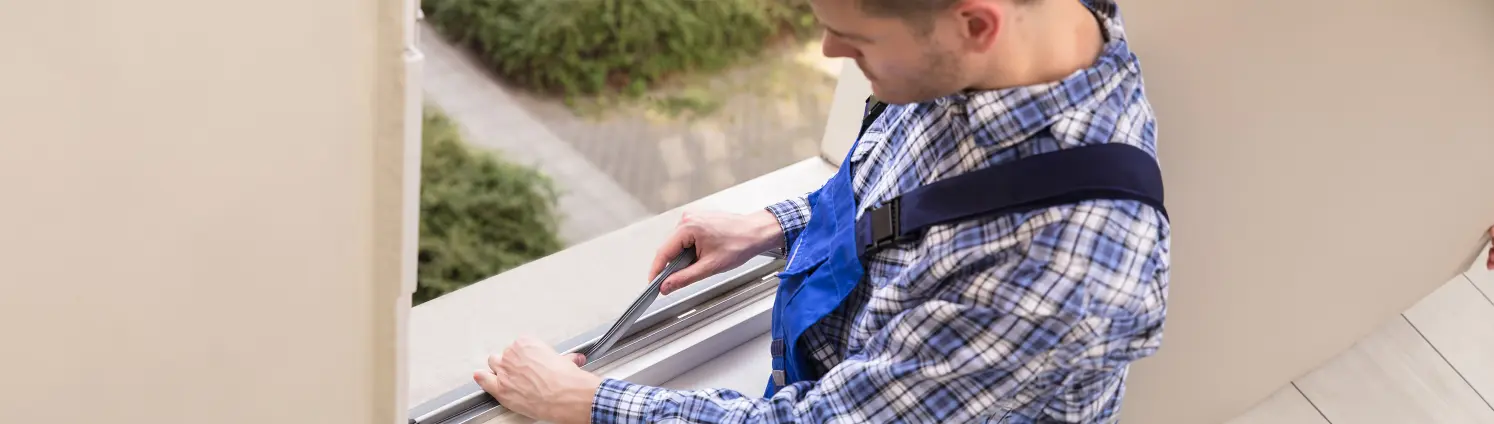 Ein Handwerker der Fenster verdichtet