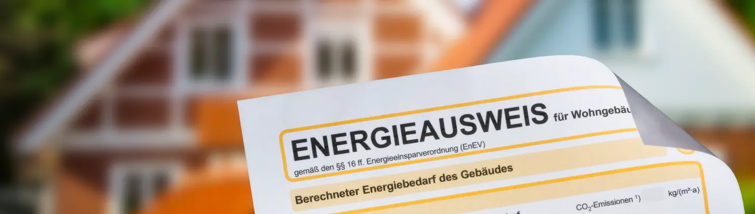 Energieausweis vor einem Einfamilienhaus im Hintergrund