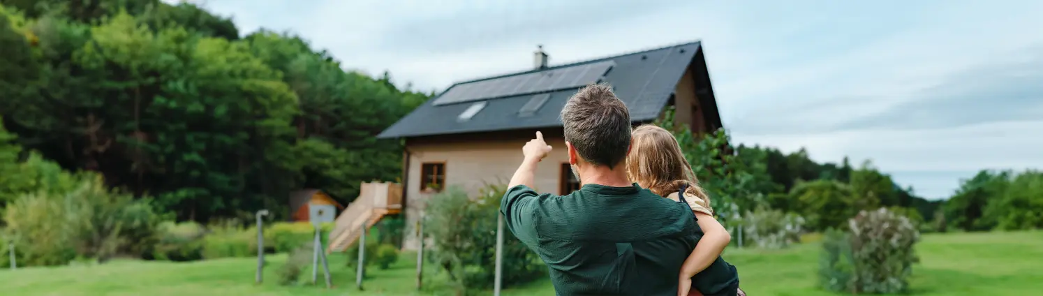 Mann zeigt Kind ihre Photovoltaik-Anlage auf dem Dach