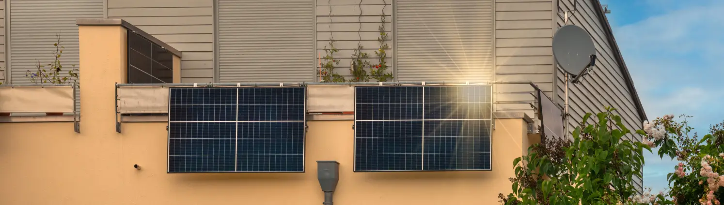 Balkon-Solarkraftwerk am Balkon an einem orangen Wohnhaus