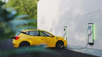 Elektroauto an einer Ladestation und weitere Ladestationen an der Wand