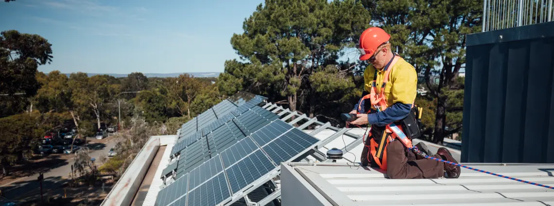 Ein Mann wartet eine Solaranlage auf einem Dach