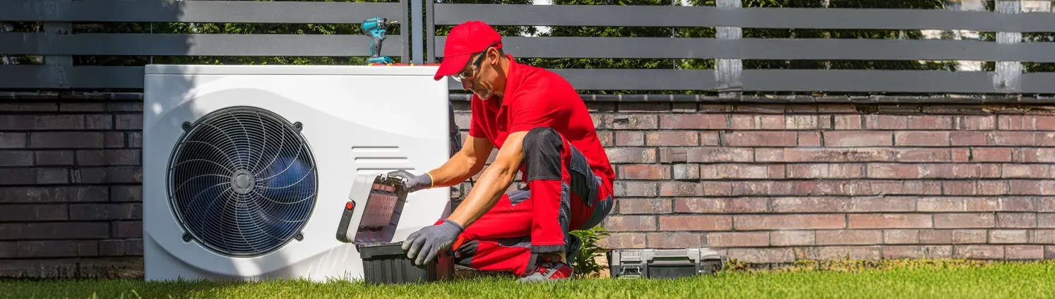 Installateur wartet eine Wärmepumpe im Garten