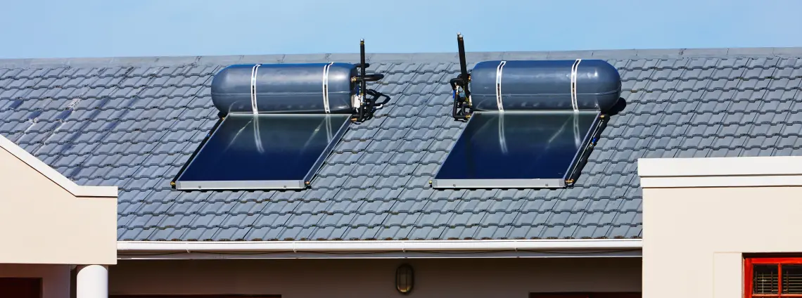 Solare Warmwasserflaschen auf dem Dach eines neuen Hauses