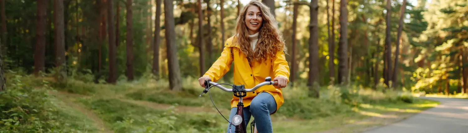 Eine Frau fährt mit dem Fahrrad durch einen Wald