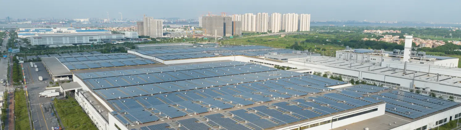 Eine PV Anlage auf dem Flachdach einer großen Lagerhalle in einem Gewerbegebiet